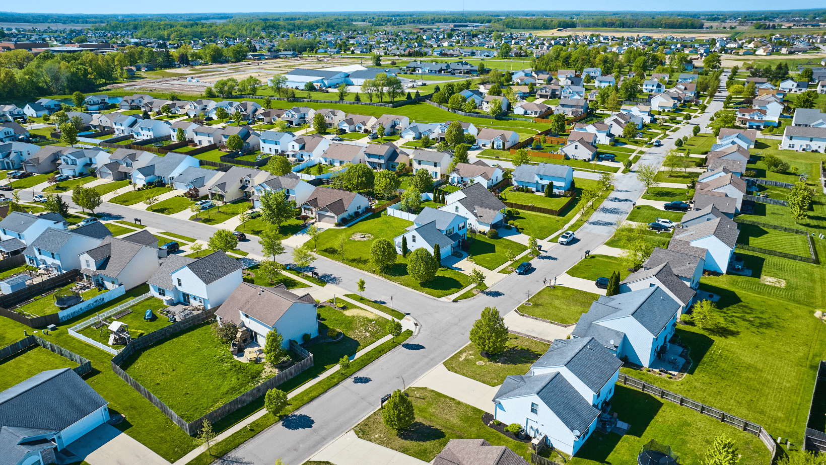 Aerial view of an HOA-governed suburban neighborhood with rows of single-family homes.