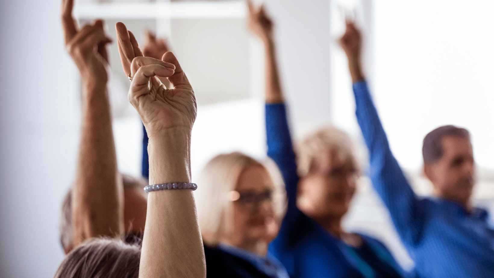 Community members raising hands during HOA vote on rule changes